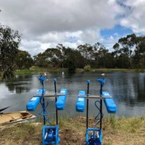 two irrigation pumps beside a lake