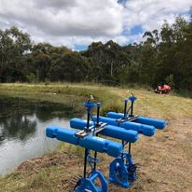 unused irrigation pumps beside a lake